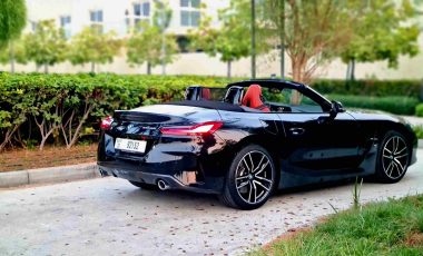 A black convertible BMW Z4 car from the back side in a natural place