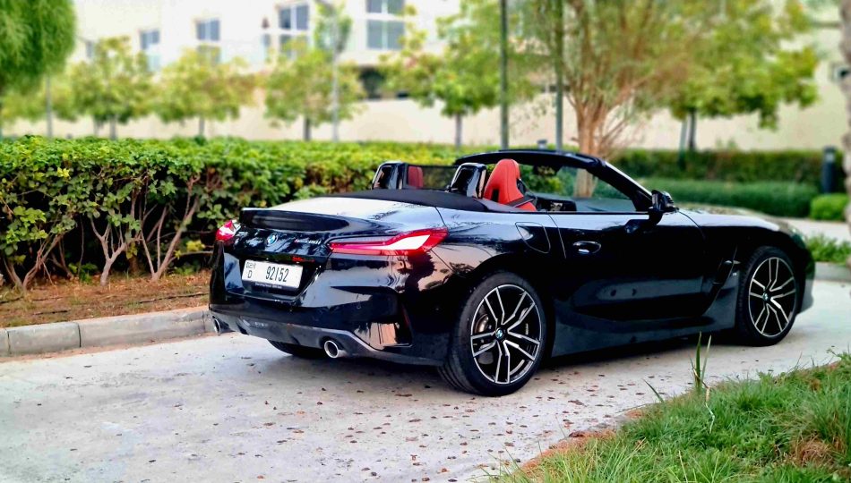 A black convertible BMW Z4 car from the back side in a natural place